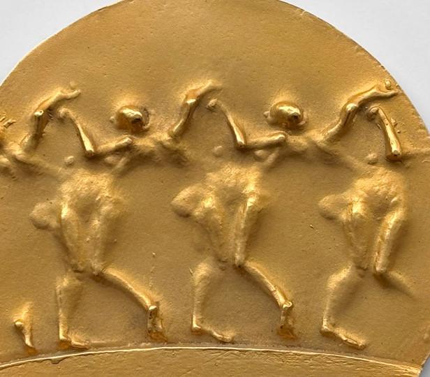 An image of the front of the gold National Medal of Arts award